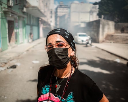 A woman in a smoky street wears a face mask