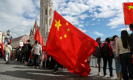 People with large Chinese flags in old area of town