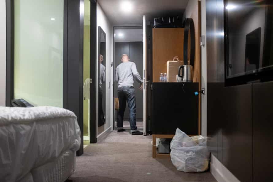 An arrival to Australia collects their dinner in a paper bag during their two-week mandatory quarantine period at a hotel in Sydney.