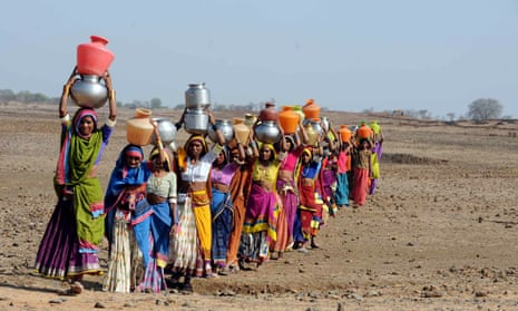 Indian tribal Lambadi women carry drinking water home to Mukunda Nayak Tanda village in the Medak district