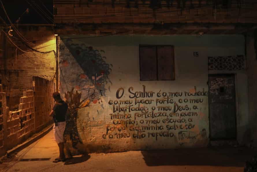 A drug trafficker stands next to a mural of Psalm 18: ‘The Lord is my rock and my fortress and my deliverer’