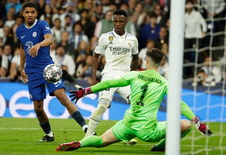 Real Madrid's striker Vinicius Jr (centre) dinks the ball past Chelsea's keeper Kepa Arrizabalaga.