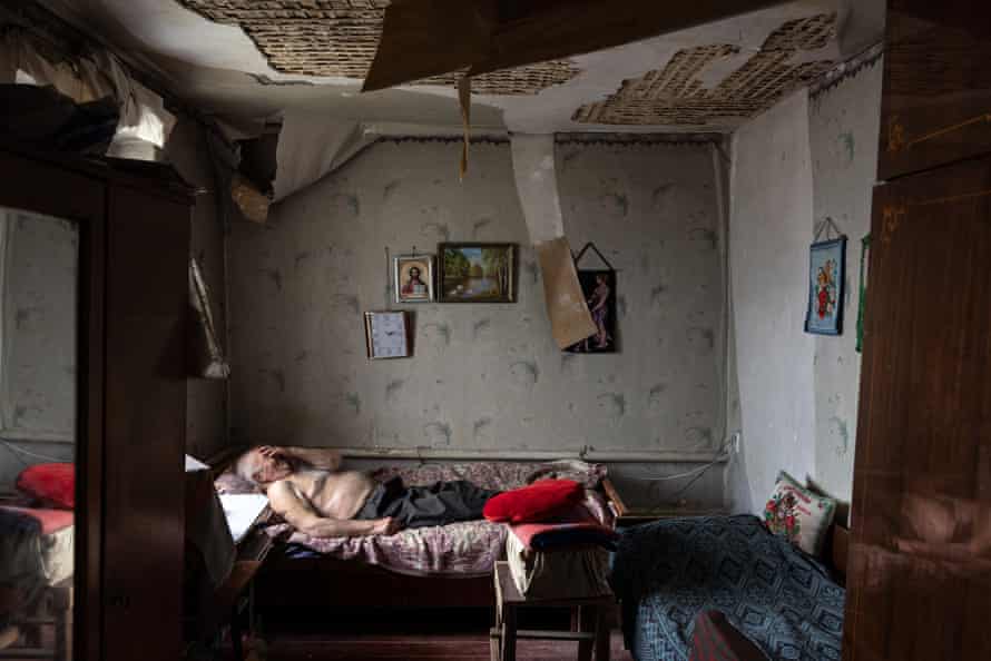 Olexiy Pshenychnykh, 85, rests in his war-damaged home to the east of Kharkiv in Vilkhivka, Ukraine.