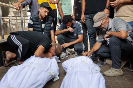 Palestinian people mourn loved ones killed while seeking aid near Zikim, west of Beit Lahiya in the northern Gaza Strip.