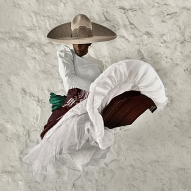A woman in a wide brimmed hat and wearing a flowy white dress jumping mid-air.