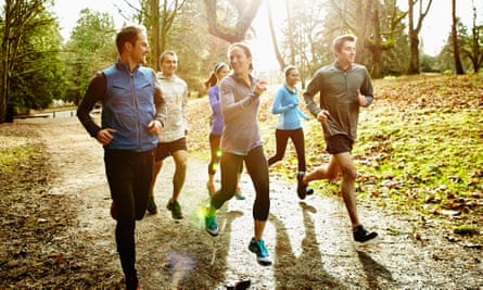 Smiling people running together in a park