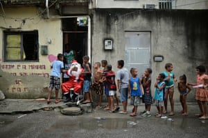 Leandro Souza, 28, who lives in the Maré favela, distributes gifts to children