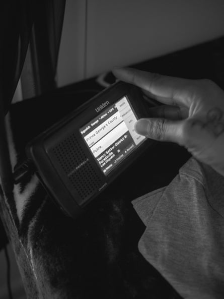 A hand operates a small electronic device.