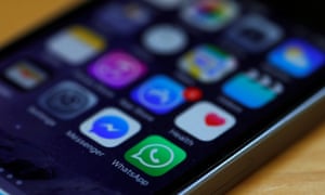 WhatsApp and Facebook messenger icons are seen on an iPhone