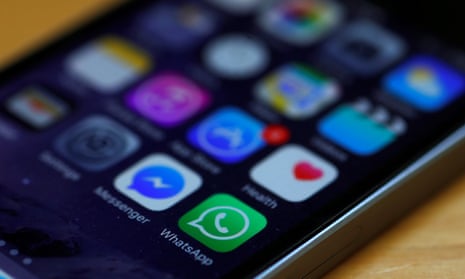 WhatsApp and Facebook messenger icons are seen on an iPhone