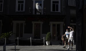 Pedestrians wearing protective face masks to curb the spread of coronavirus walk in outside a closed coffee shop, in Psiri district of Athens, on Friday.
