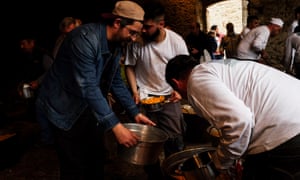 Salvatore Aloe holding out a large tin pan to receive his pasta