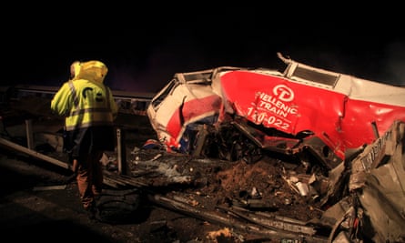 A man walks at the scene of a crash, where two trains collided, near the city of Larissa