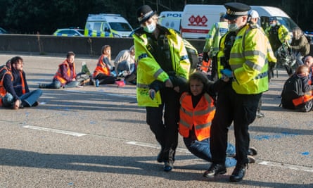 Police remove an Insulate Britain activist from the M25, September 2021.