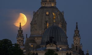 Dresden, Germany. The moon sets in the morning behind the Frauenkirche and the dome of the Künstakademie with the angel Fama