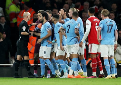 Referee Anthony Taylor awards Arsenal a penalty as Manchester City's Ilkay Gundogan and teammates react dispute his decision.