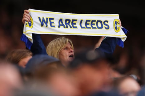 A fan holds aloft a scarf which reads 'We Are Leeds'