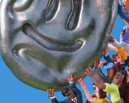 Large metallic smiley shape being pushed by a crowd of small people