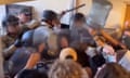 blurry photo shows clash between officers and protesters, with one protester brandishing a water jug