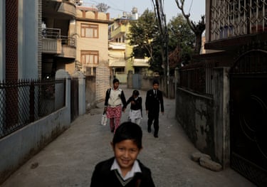 Four members of the Subedi family walk through a street in Lalitpur