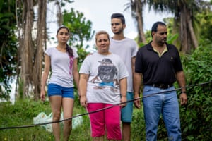 Diana Ivelisse Vera Maldonado, Jose Ruiz Gonzalez, and their children in front of their house with the disconnected power line.