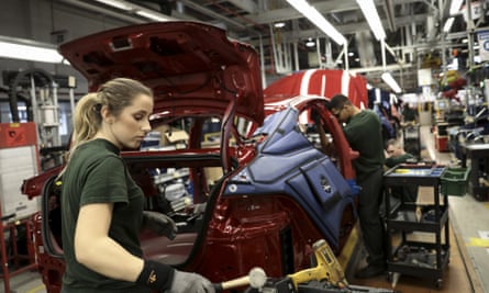 Employees works on a Jaguar automobile on the production line at Tata Motor