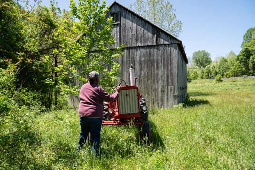 A woman checks a red tractor