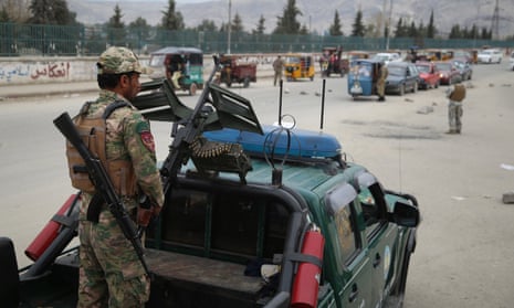 Afghan security officials check people at a checkpoint on the outskirts of Jalalabad, Afghanistan