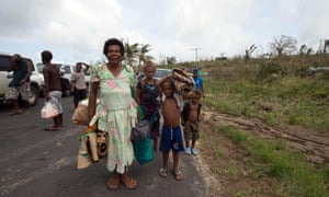 Local residents carry their belongings along a road.