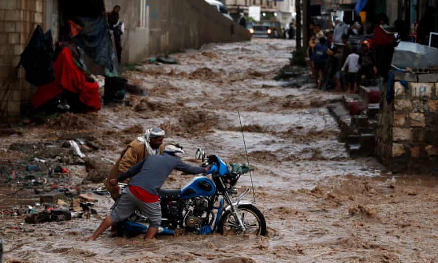 Yemenis attempt to get a motorcycle out of floodwater caused by heavy rainfall in Sanaa, Yemen, in July 2020.