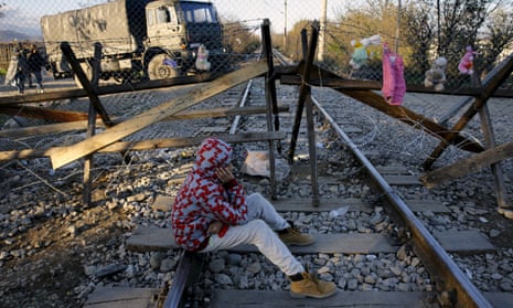 Efran, 12, a stranded Iranian migrant sits on rail tracks in front of part of a fence erected on Sunda at the Greek-Macedonian border near the Greek village of Idomeni.