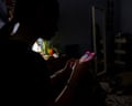 silhouette of a teenage girl sitting inside room on cellphone