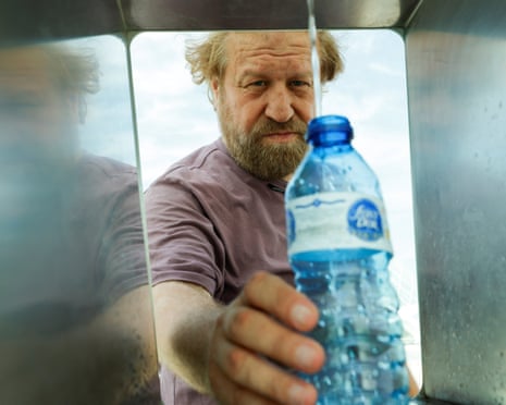 A man fills his water bottle at a drinking fountain during a heatwave at the City of Arts and Sciences in Valencia, Spain.