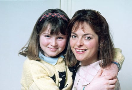 Close up of Janet Ellis (wearing a pink shirt) being hugged by her daughter Sophie Ellis-Bextor (in yellow knitted cardigan with black cat motif) 1989.