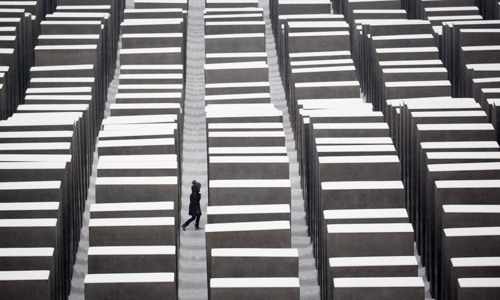 A visitor walks through the snow covered Holocaust memorial in Berlin.
