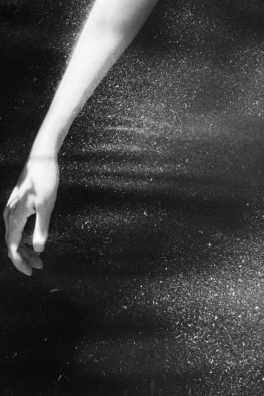 A womans hand dappled in light and water