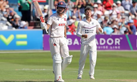 Alastair Cook raises his bat to acknowledge his fifty at Chelmsford in the sun.