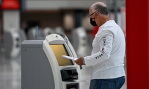 A passenger checks in at the Qantas departures terminal at Sydney airport today.