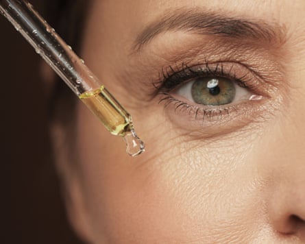 Closeup of female eye and dropper with rejuvenating serum