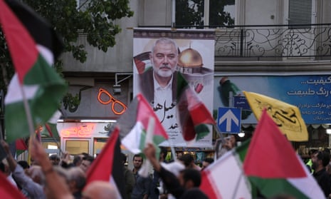 Iranian protesters wave Palestinian flags under a portrait of Hamas leader Ismail Haniyeh after his assassination in Tehran