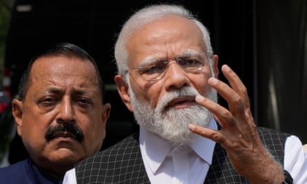 Narendra Modi gestures, with another man visible over his shoulder