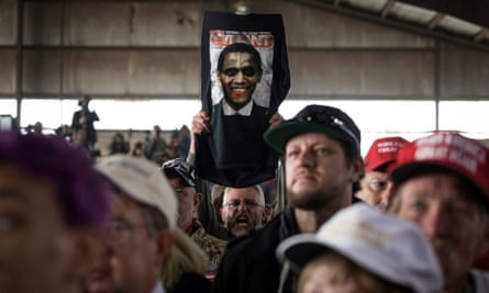 A man holds up an image of Barack Obama with the word ‘tyrant’ above itduring a Trump rally in Colorado Springs.