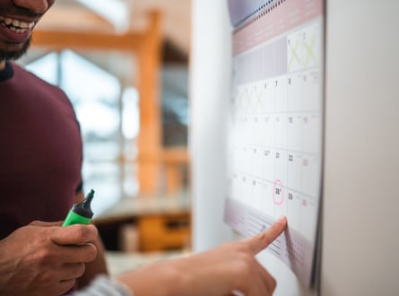 Close-up shot of a man and woman looking at a calendar