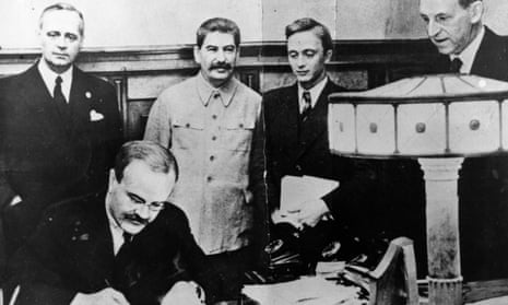 Vyacheslav Molotov, Russian foreign minister, signs the non-aggression pact negotiated between Soviet Russia and Germany, at the Kremlin, Moscow. Standing behind him is his German counterpart Joachim von Ribbentrop (left), and Joseph Stalin (centre), 23 August 1939.