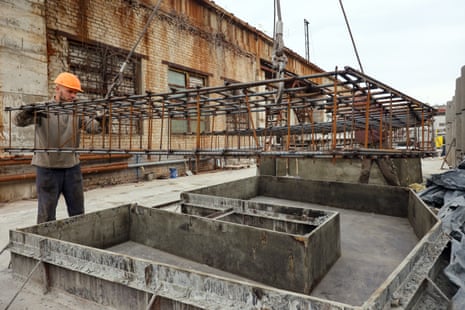Men are seen during the production of the components for a concrete bomb shelter in Kharkiv.