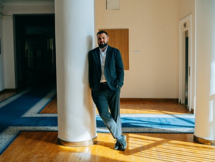 Ihor Bezkaravainyi standing leaning against a column in a room.