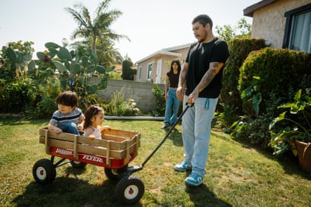 Two people playing with children in a wagon