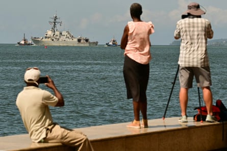people watch a warship