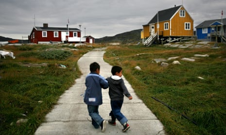 Two boys walking away from us in a Greenland village