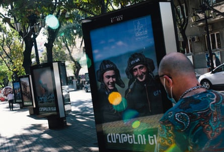 A man walks past advertising boards in the centre of Yerevan showing pictures from the Nagorno-Karabakh frontlines